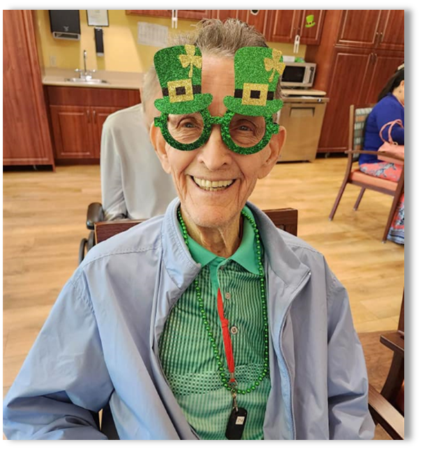 memory care resident with St Patricks glasses