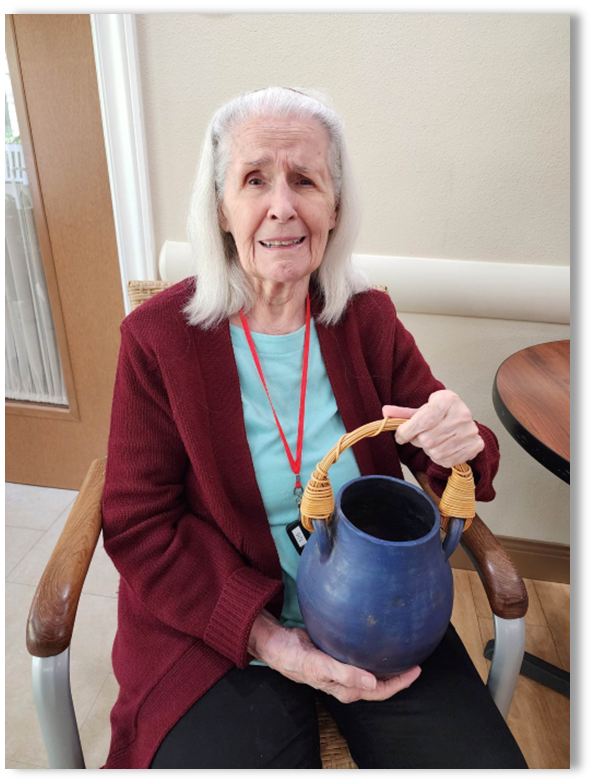 memory care resident sitting holding a blue pot