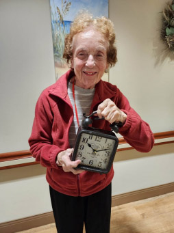 senior resident holding a clock