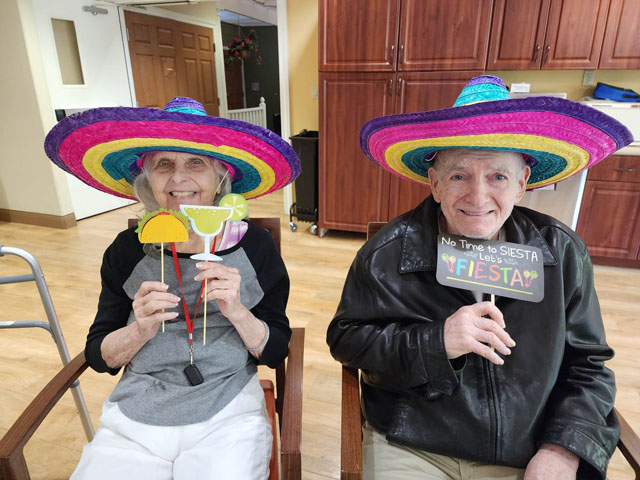 memory care residents sitting wearing sombrerors