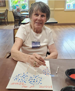 memory care resident painting fireworks for the celebration