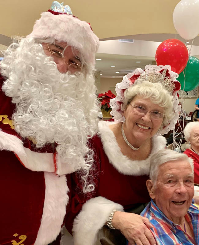 assisted living resident happy with Santa and mrs Claus