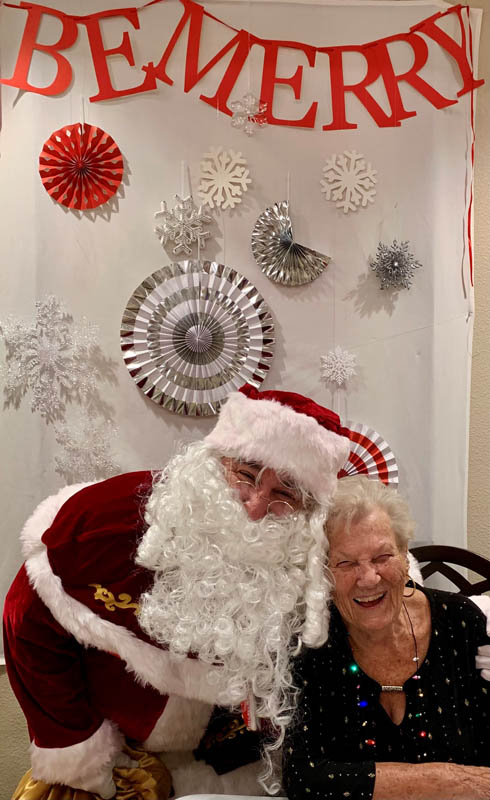 assisted living resident laughing with Santa