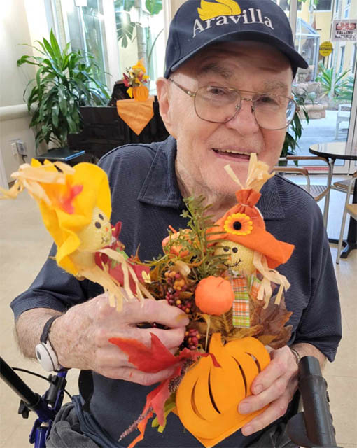 happy memory care resident showing off crafts