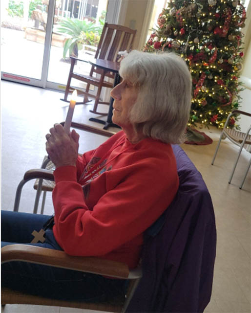 senior residents participating in the service hands folded in prayer