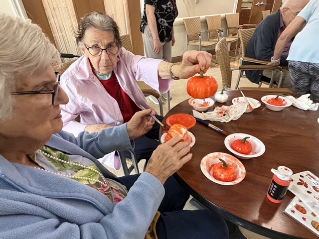 memory care residents decorating pumpkins